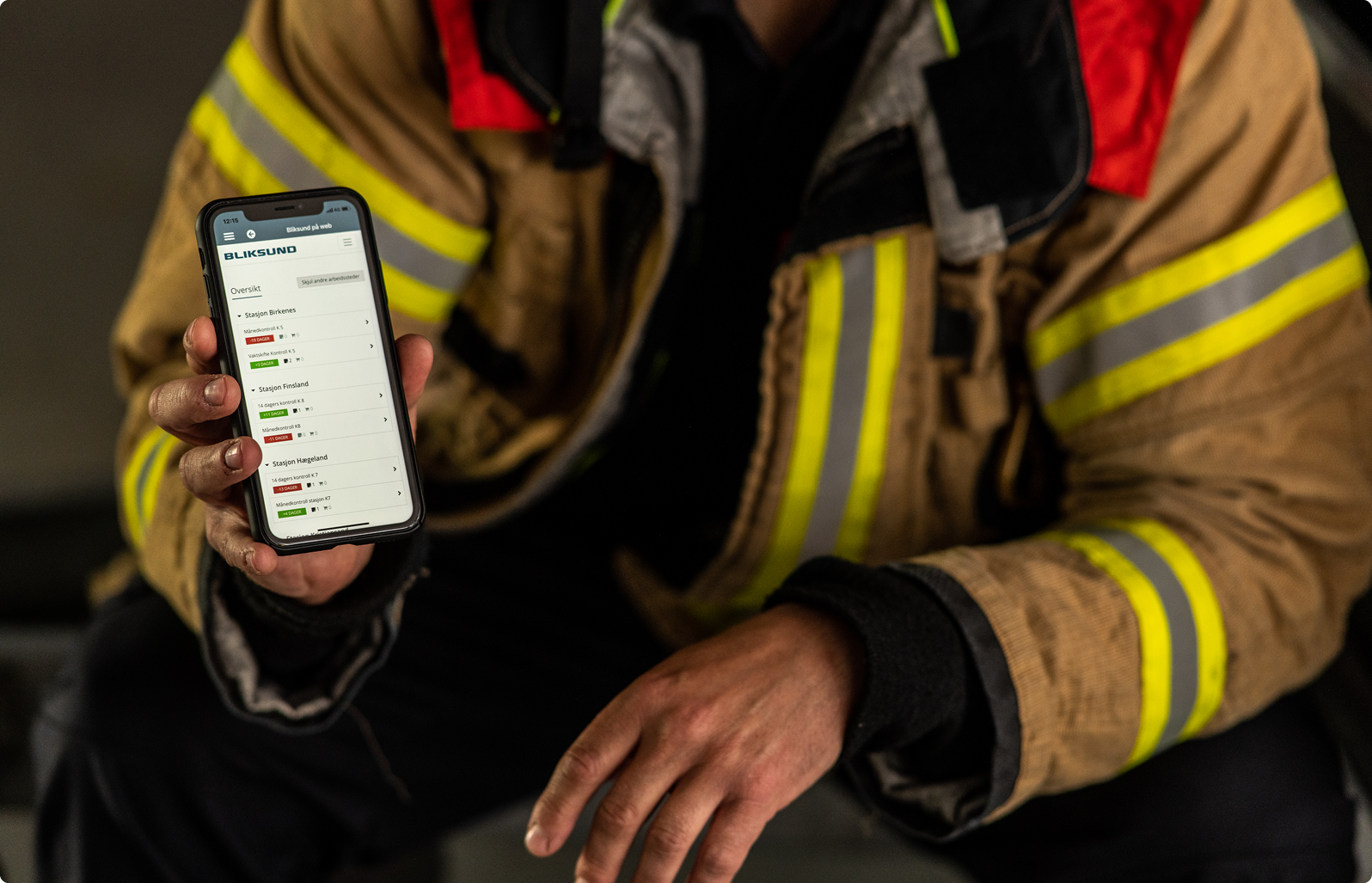 Brandweerman toont het operationele professionele systeem GRID op een smartphone